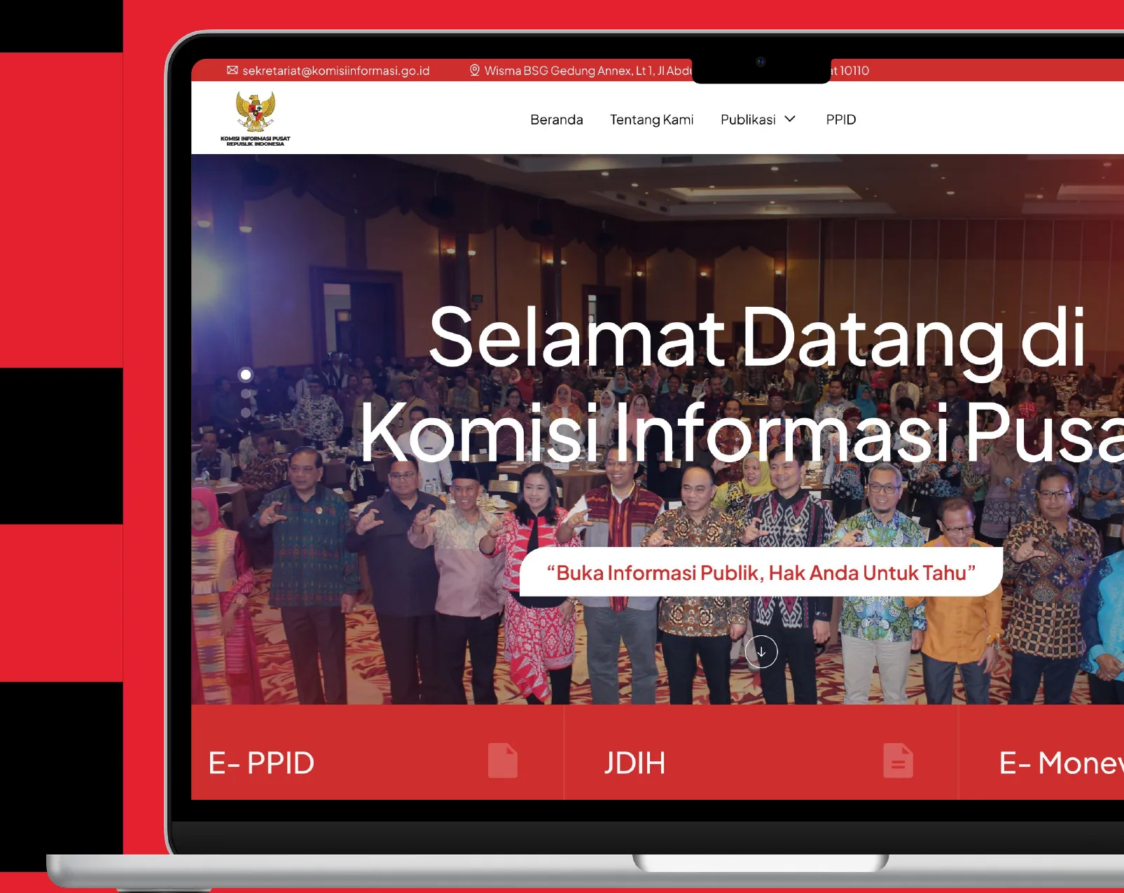 Komisi Informasi website on a laptop: “Selamat Datang di Komisi Informasi Pusat” over a group photo